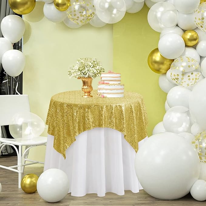 Gold sequin tablecloth on a dessert table with balloon garland